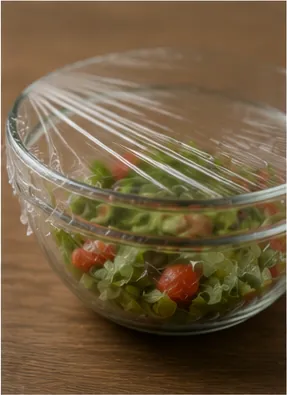 Illustration of cling wrap stick to a bowl without glue for the question "Why does cling wrap stick to a bowl without glue?"